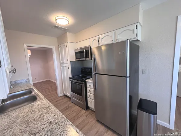a kitchen with a refrigerator a stove top oven and a refrigerator