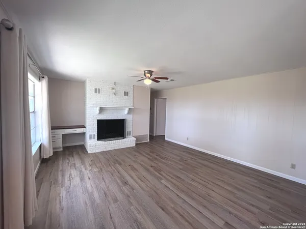 wooden floor in an empty room with a fireplace