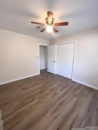 a view of an empty room with wooden floor