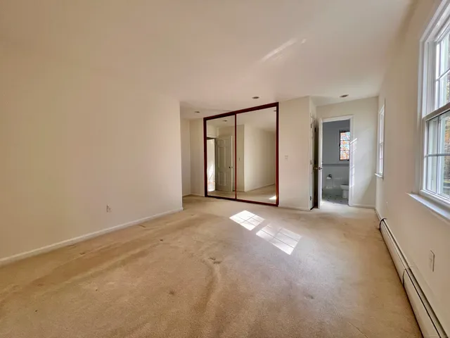 an empty room with windows and closet