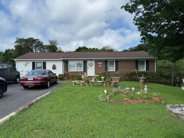 a front view of a house with a garden and trees