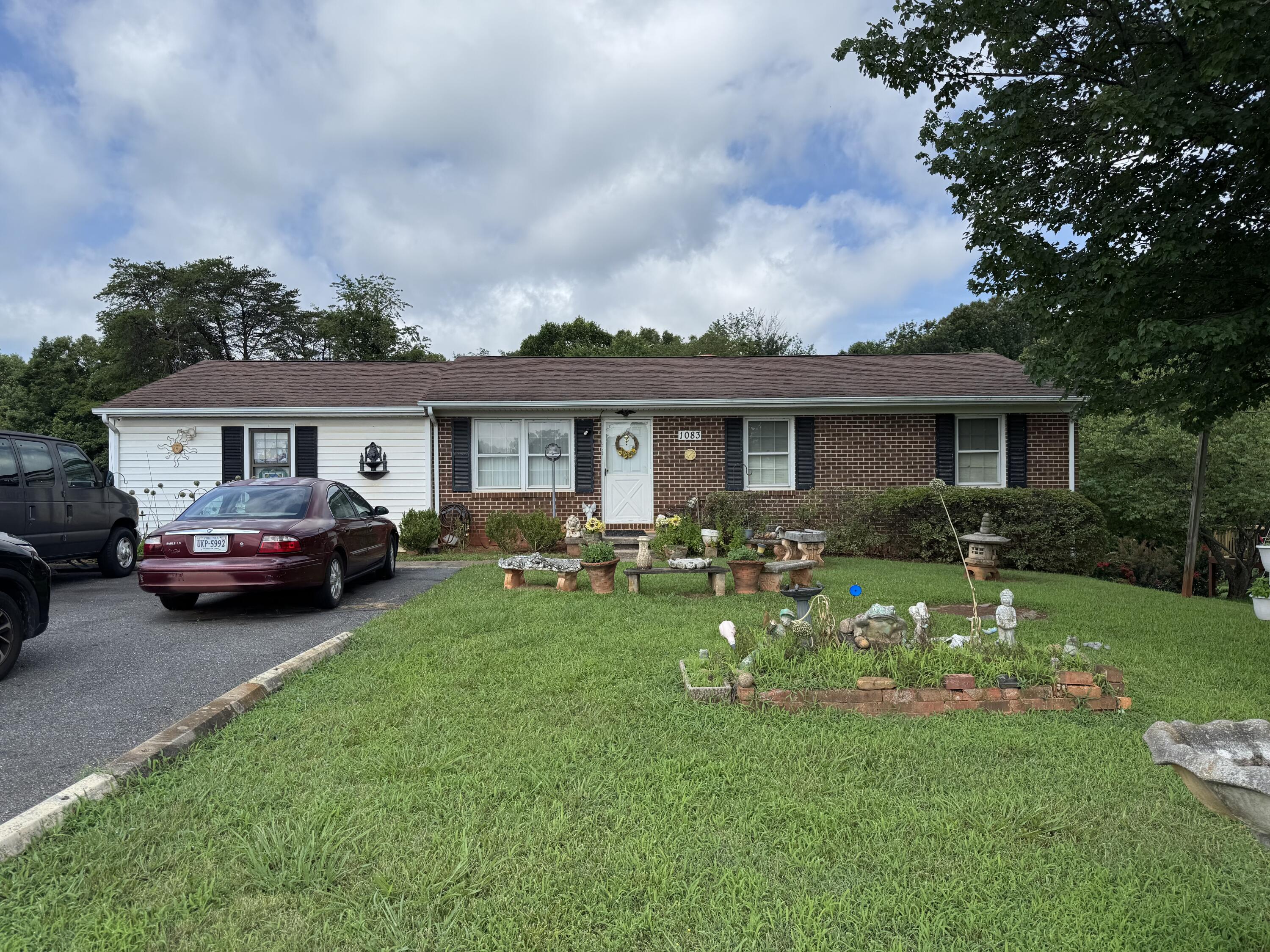 a front view of a house with a garden and trees