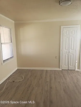 a view of empty room with wooden floor