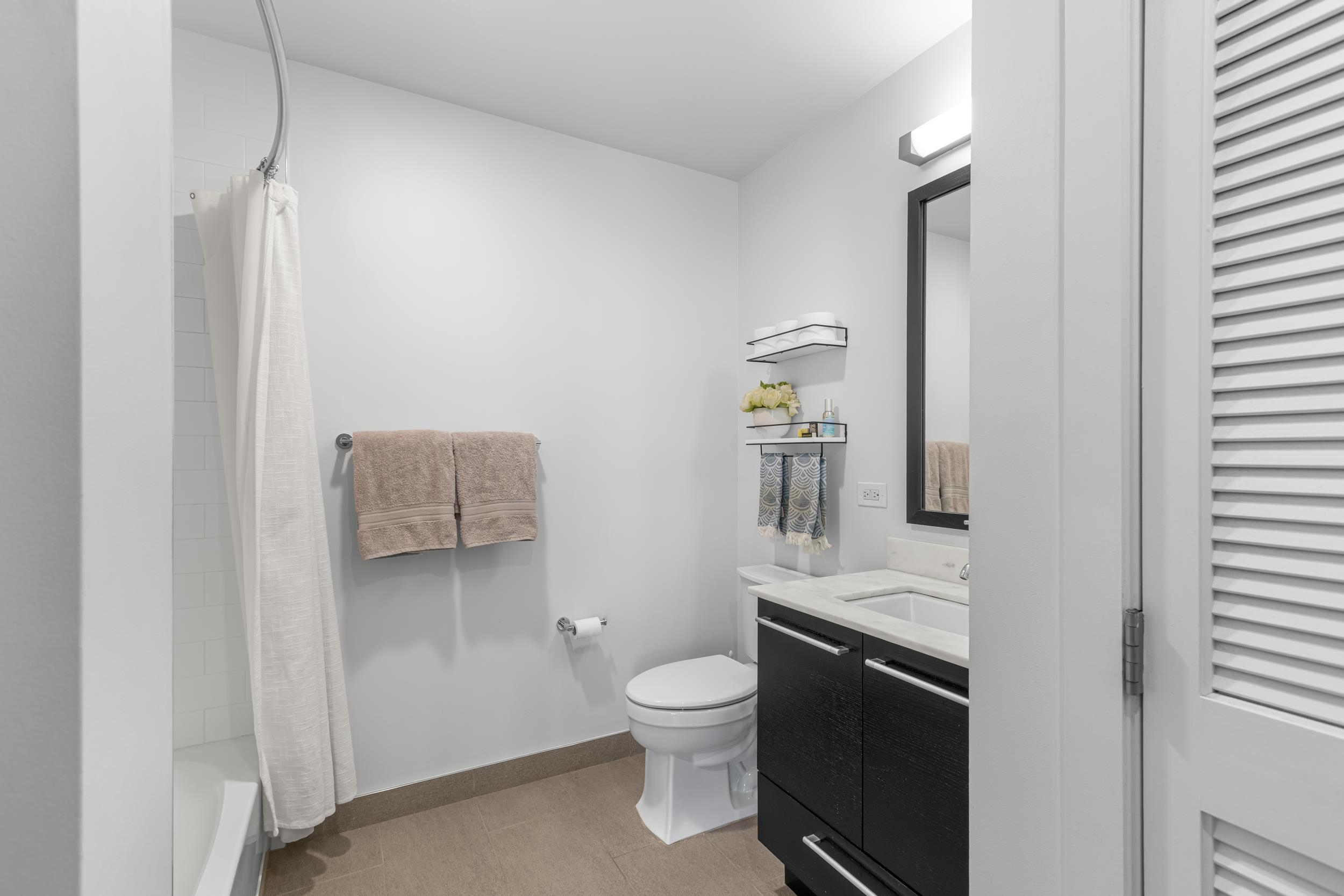 1450 Washington Street, Unit 608 Hoboken, NJ 07030 - Photo 15 of 44 a bathroom with a toilet a sink and mirror