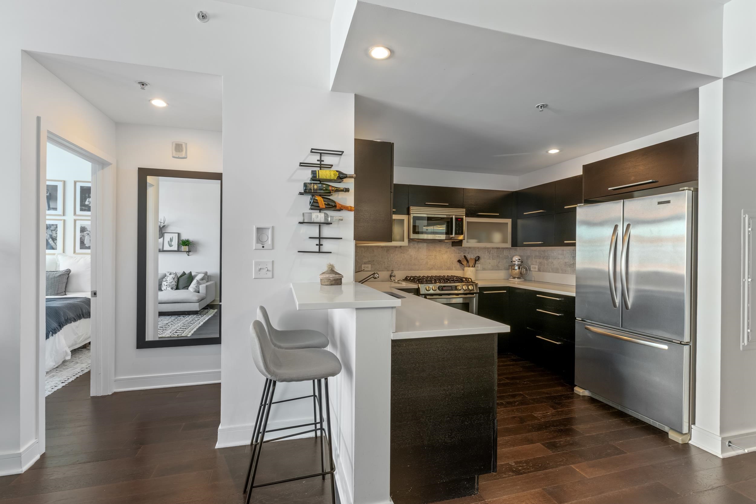 1450 Washington Street, Unit 608 Hoboken, NJ 07030 - Photo 5 of 44 a kitchen with refrigerator a sink and chairs
