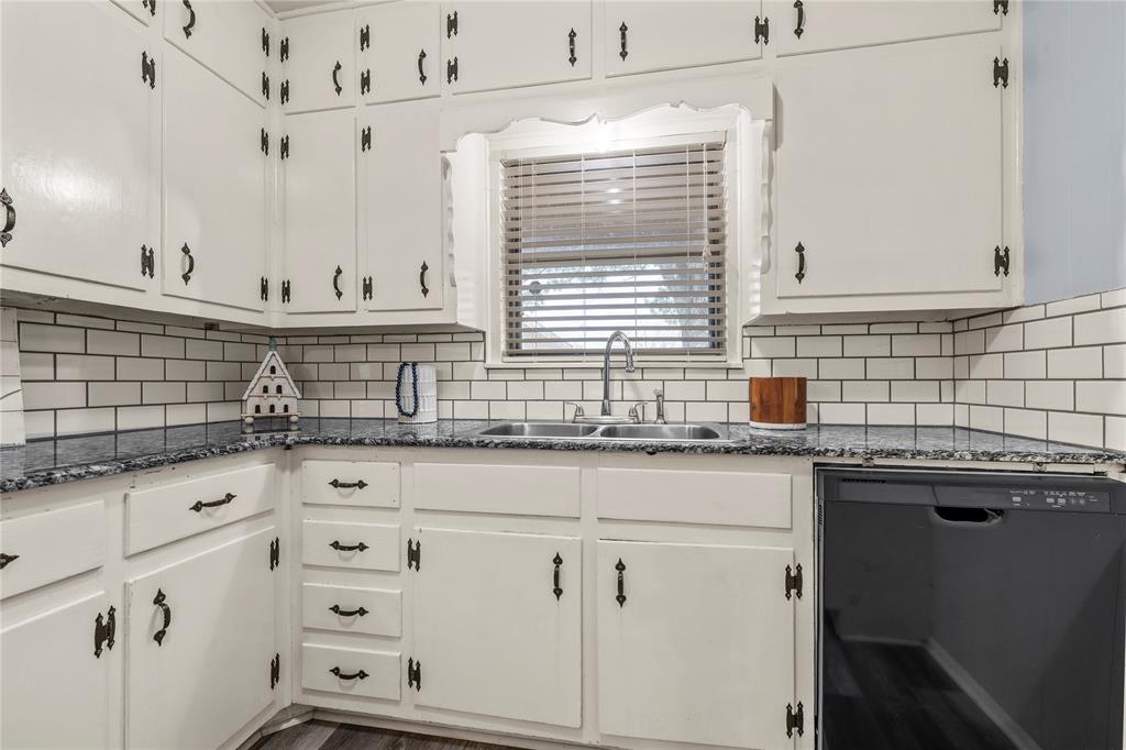 901 North Main Street West, TX 76691 - Photo 14 of 32 a kitchen with granite countertop white cabinets and sink