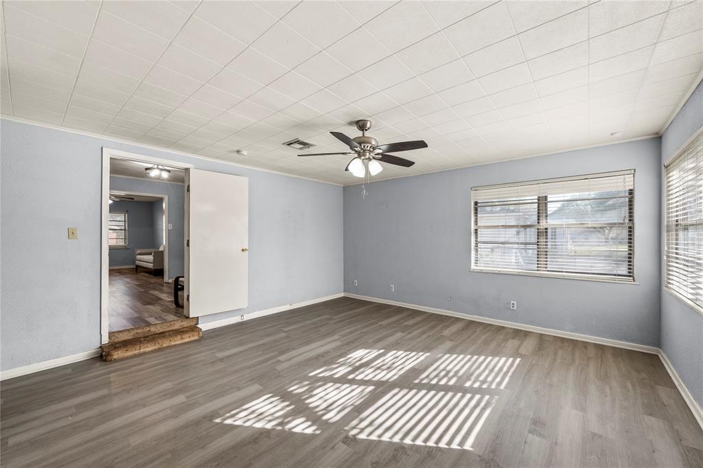 901 North Main Street West, TX 76691 - Photo 23 of 32 an empty room with wooden floor chandelier fan and windows