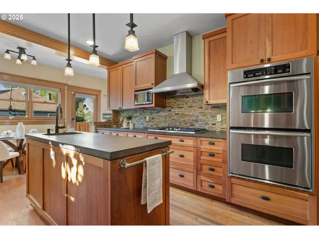 a kitchen with stainless steel appliances granite countertop a stove a sink and a microwave