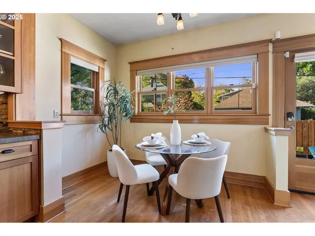 a dining room with furniture a large window and wooden floor
