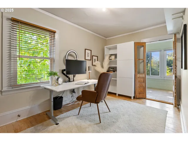 a view of a workspace with furniture and a window