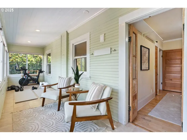 a living room with furniture a large window and wooden floor