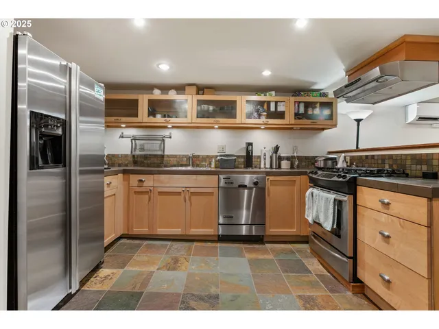 a kitchen with stainless steel appliances granite countertop a stove a sink and a refrigerator