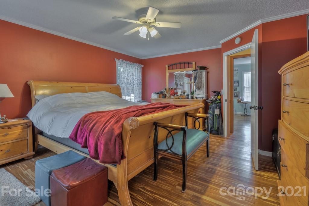 125 Mountainview Road Landrum, SC 29356 - Photo 17 of 48 a bedroom with a bed a dresser and wooden floor