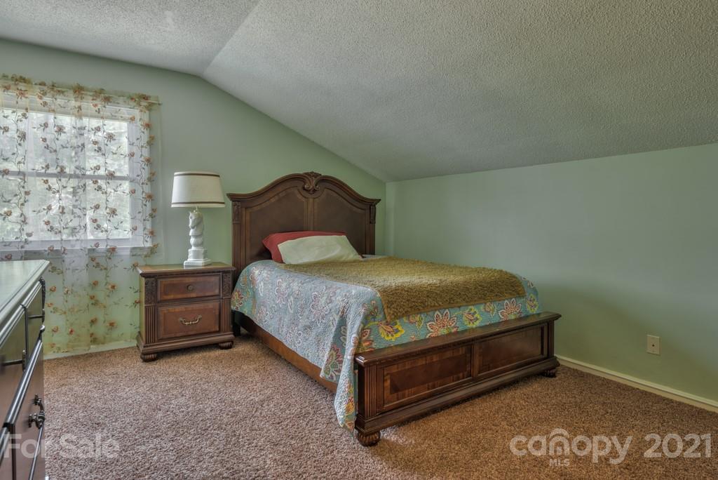 125 Mountainview Road Landrum, SC 29356 - Photo 23 of 48 a bedroom with a bed and cabinets