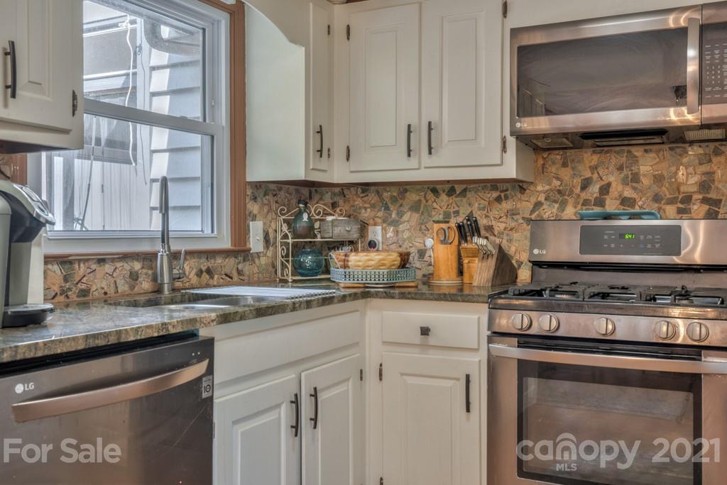 125 Mountainview Road Landrum, SC 29356 - Photo 8 of 48 a kitchen with stainless steel appliances granite countertop white cabinets and a stove top oven