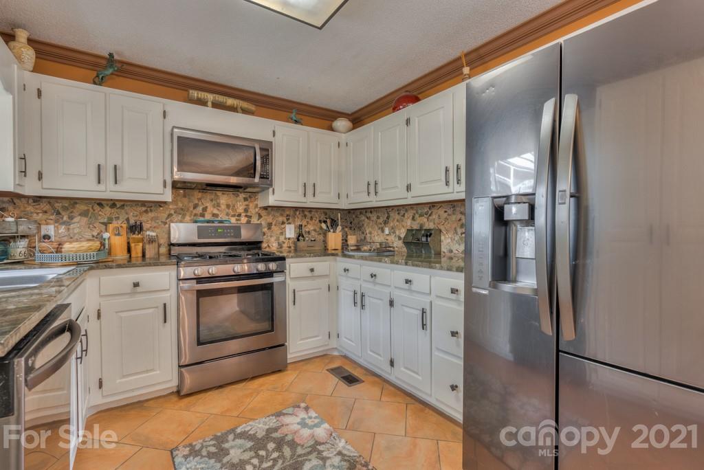 125 Mountainview Road Landrum, SC 29356 - Photo 9 of 48 a kitchen with stainless steel appliances granite countertop a refrigerator sink and stove