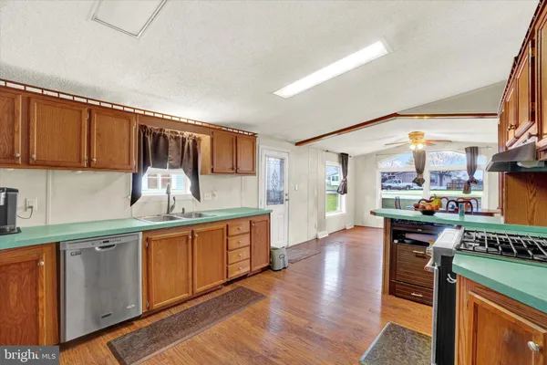 a kitchen with stainless steel appliances a stove top oven a sink dishwasher and cabinets