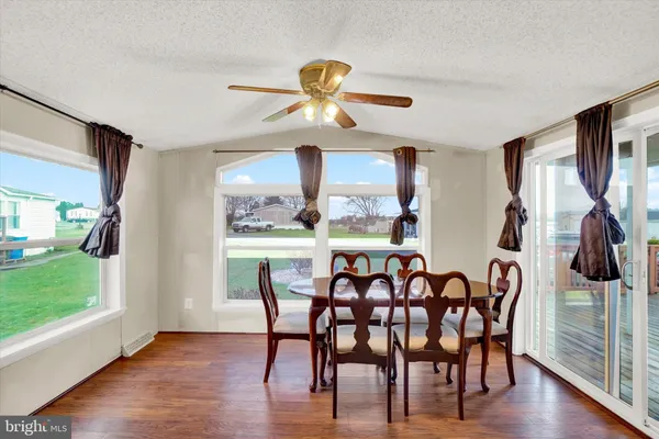 a dining room with furniture a chandelier and wooden floor