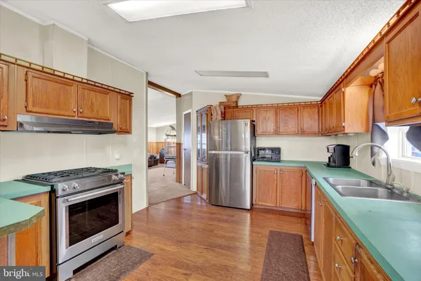 a kitchen with stainless steel appliances granite countertop a refrigerator stove and sink