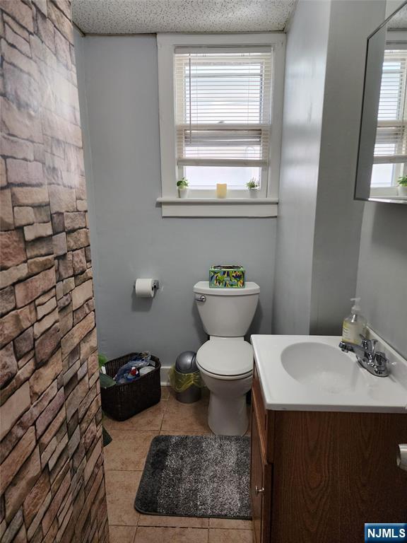 93 1st Street, Unit 1 Clifton, NJ 07011 - Photo 7 of 8 a bathroom with a toilet a sink and a window