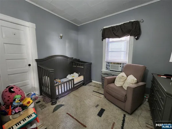a living room with furniture and a baby crib