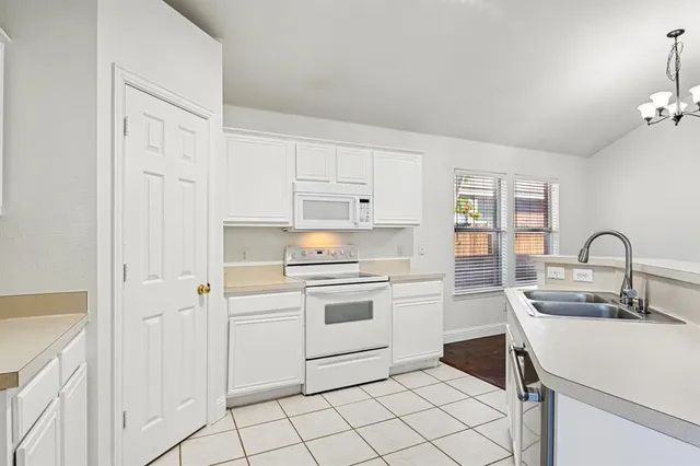 a kitchen with white cabinets appliances and sink