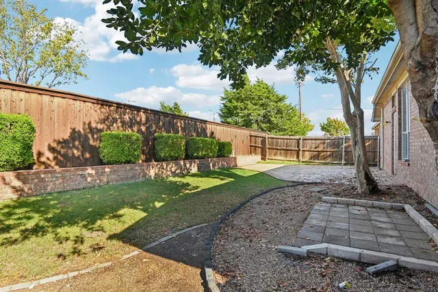 a front view of a house with a garden and trees
