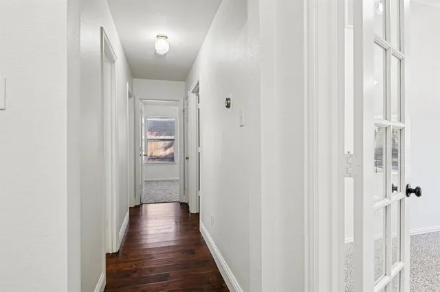 an empty room with wooden floor a fireplace a ceiling fan and windows