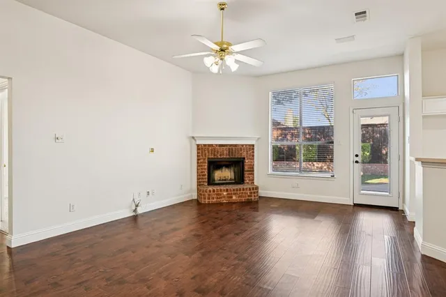 a view of a kitchen with furniture a ceiling fan wooden floor and a fire place