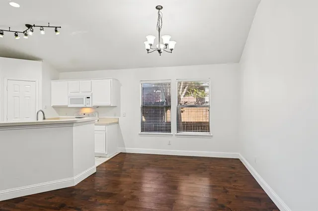 an empty room with wooden floor and window
