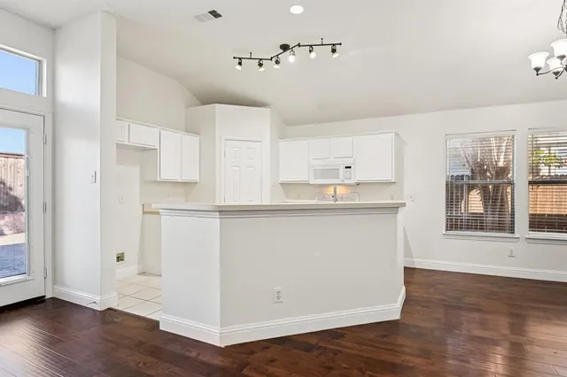 a kitchen with white cabinets appliances and sink