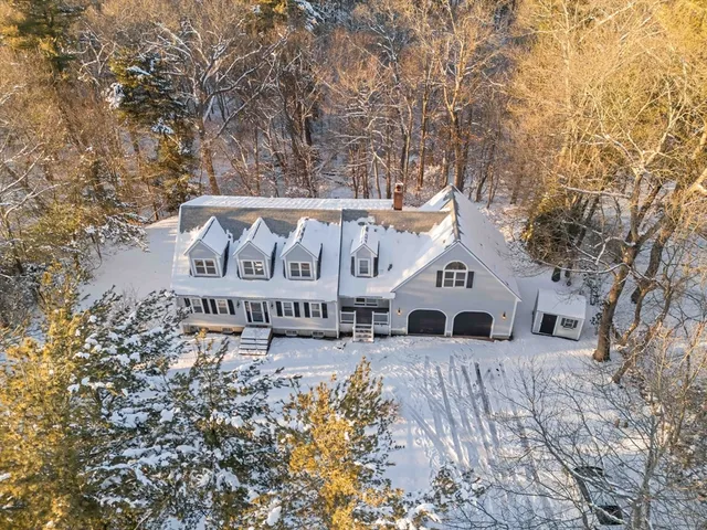 a white house with a large tree in front of it
