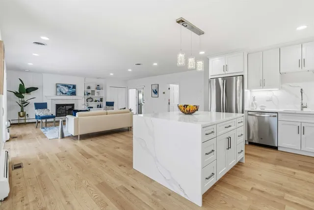 a kitchen with kitchen island white cabinets and stainless steel appliances
