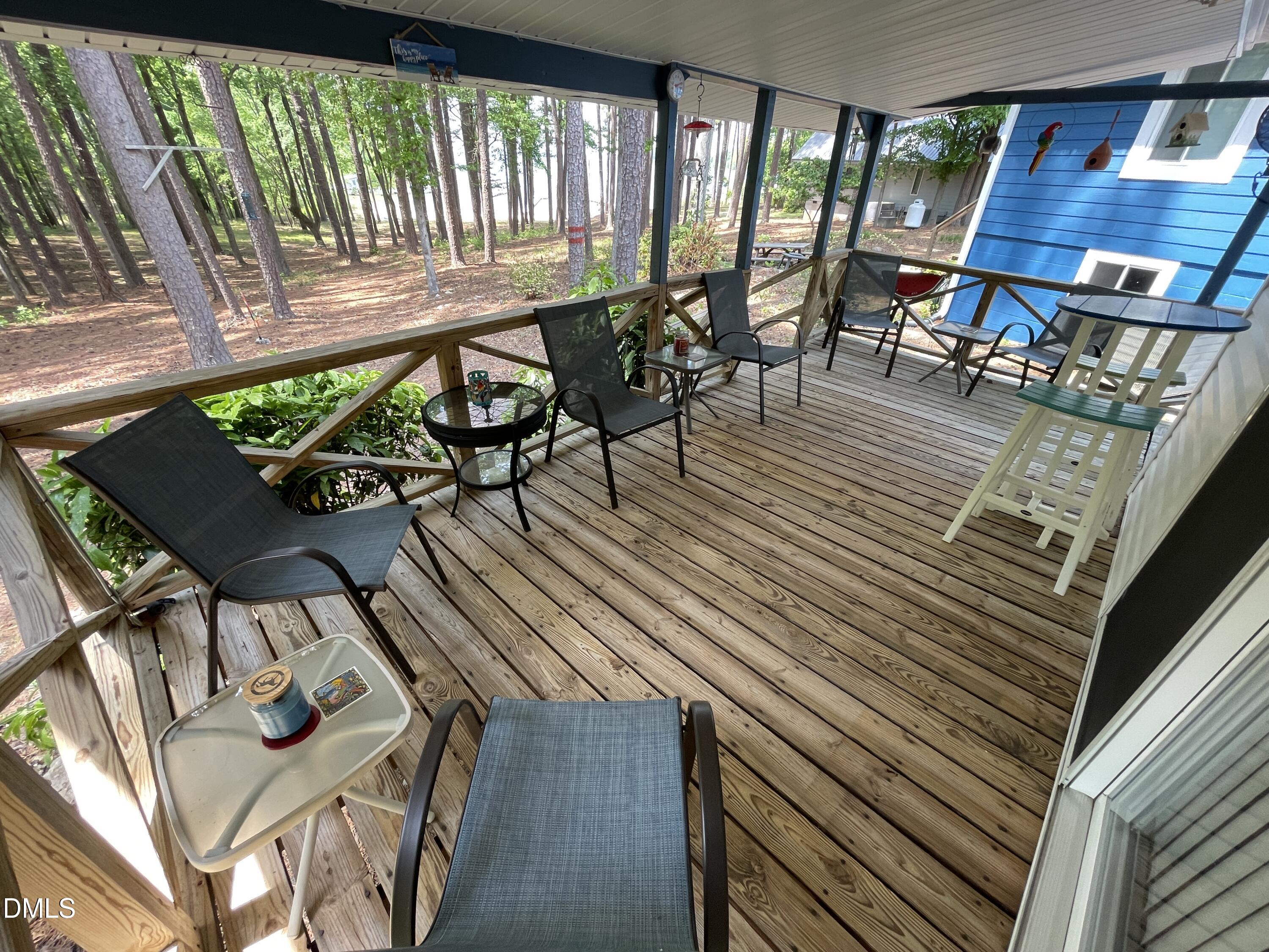 129 Boulder Boulevard Manson, NC 27553 - Photo 34 of 48 a view of a patio with table and chairs with wooden floor and fence