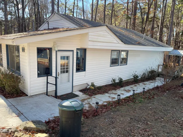 a view of a house with a yard and sitting area