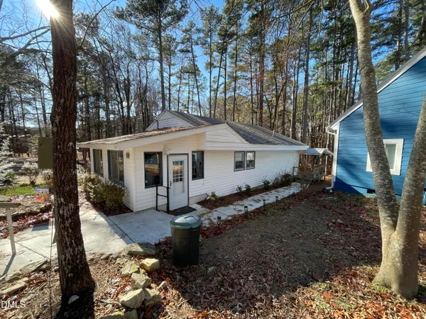 a view of a house with a yard chairs and wooden fence