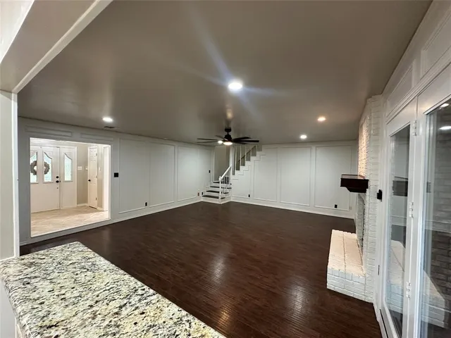 an empty room with wooden floor and fireplace