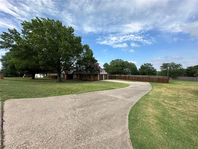 an empty room with wooden floor chandelier and entryway