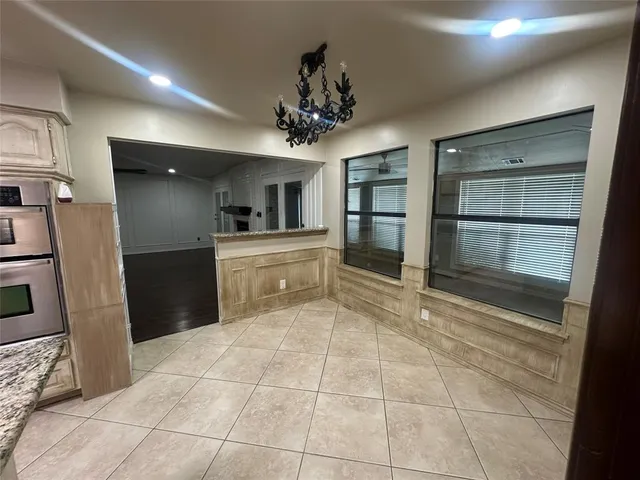 a large kitchen with a counter space a sink and stainless steel appliances
