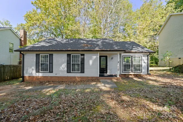 a front view of a house with a garden and yard