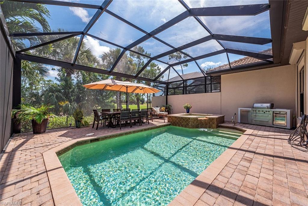 7599 Moorgate Point Way Naples, FL 34113 - Photo 13 of 24 a view of a backyard with table and chairs under an umbrella