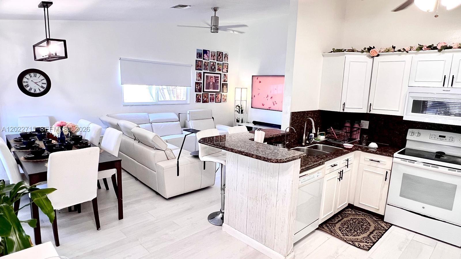 10669 Boca Entrada Boulevard Boca Raton, FL 33428 - Photo 4 of 19 a kitchen with a stove a refrigerator and a table
