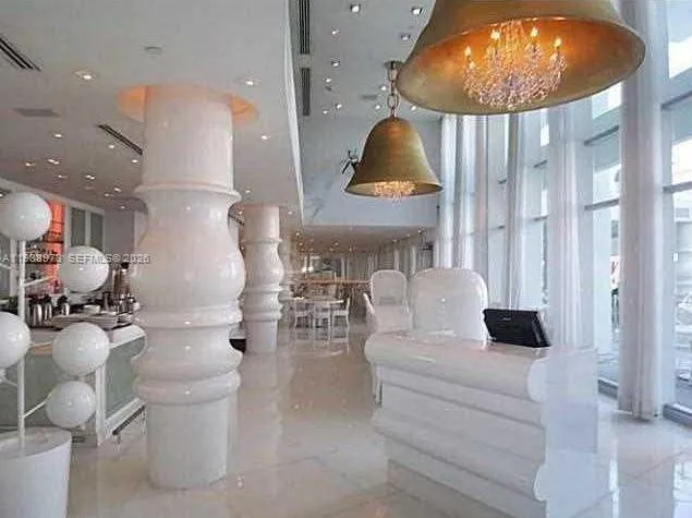 a bedroom with a bed and a lamp on dresser