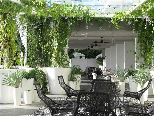 a room with furniture pool table and large windows