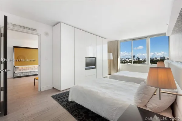 a room with a bed and a view of living room