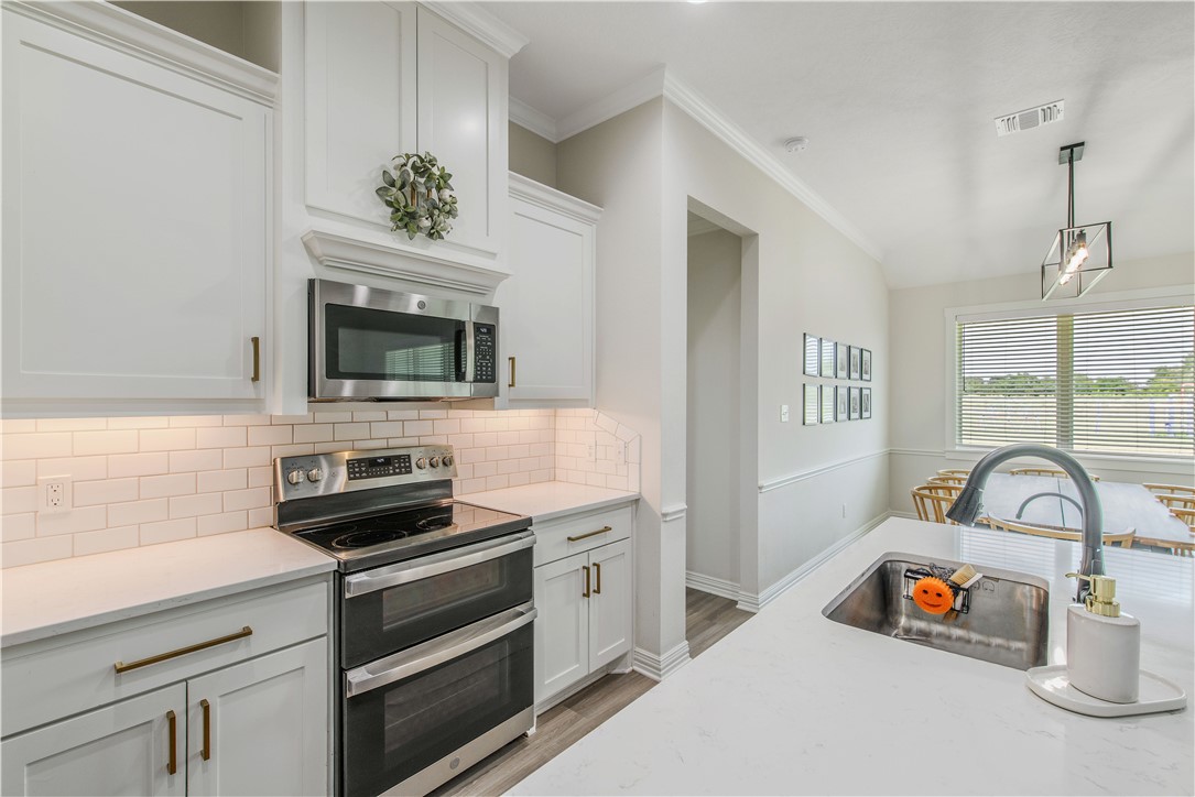 3332 Hunters Crossing Bryan, TX 77808 - Photo 25 of 26 a kitchen with a stove and a microwave
