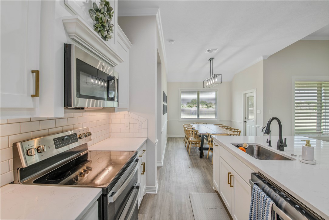 3332 Hunters Crossing Bryan, TX 77808 - Photo 26 of 26 a kitchen with kitchen island a stove sink and wooden floor