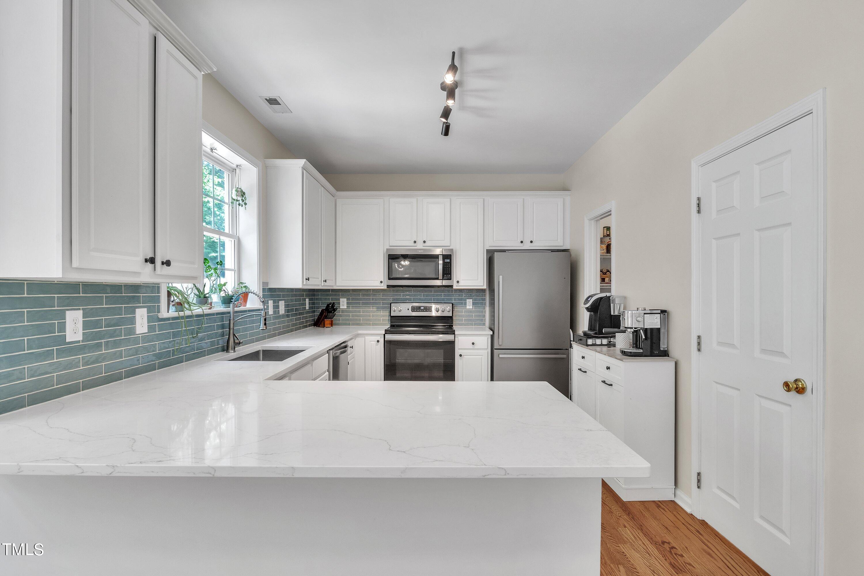 4702 Regency Drive Durham, NC 27713 - Photo 16 of 45 a kitchen with refrigerator and cabinets