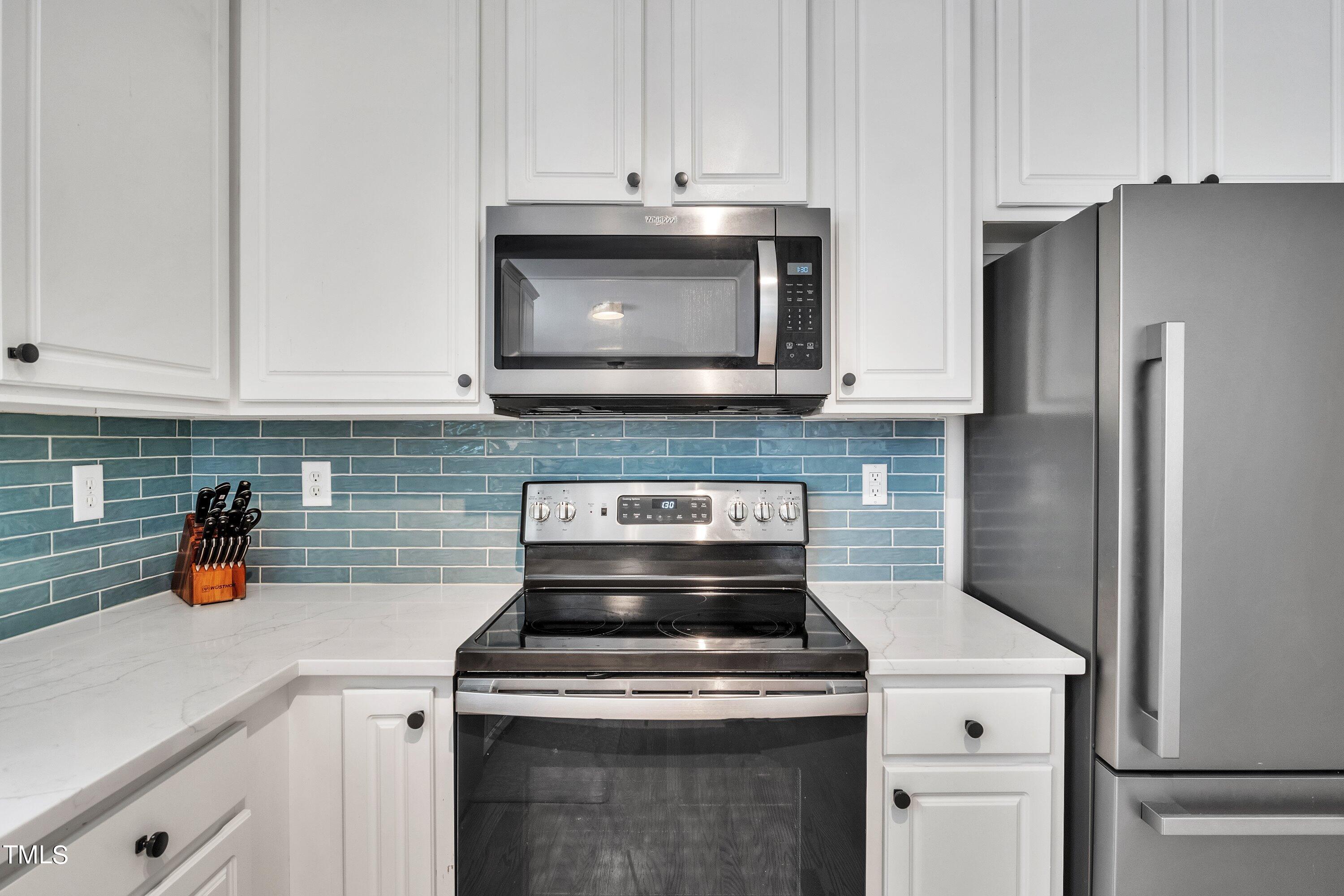 4702 Regency Drive Durham, NC 27713 - Photo 17 of 45 a kitchen with stainless steel appliances granite countertop a stove and a refrigerator