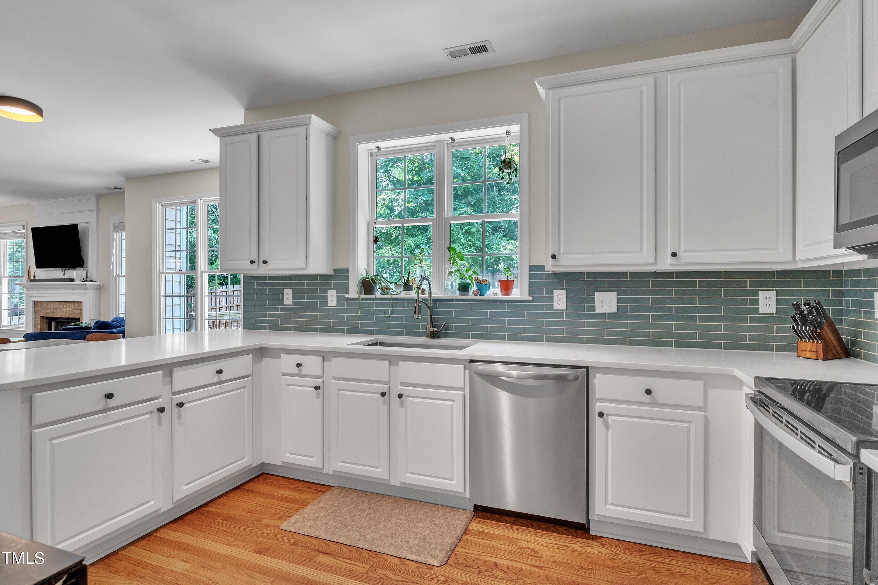 4702 Regency Drive Durham, NC 27713 - Photo 18 of 45 a kitchen with white cabinets and white appliances